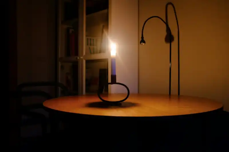 Brandende kaars op een tafel in een donkere woonkamer