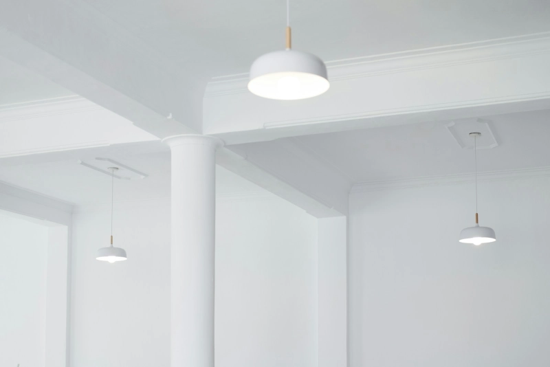 Drie witte hanglampen aan een wit plafond